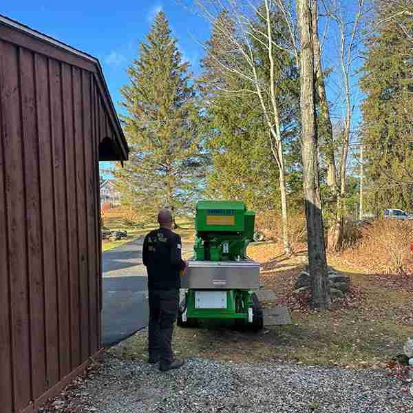 KDF Tree staff standing next to compact 90-foot tracked lift.